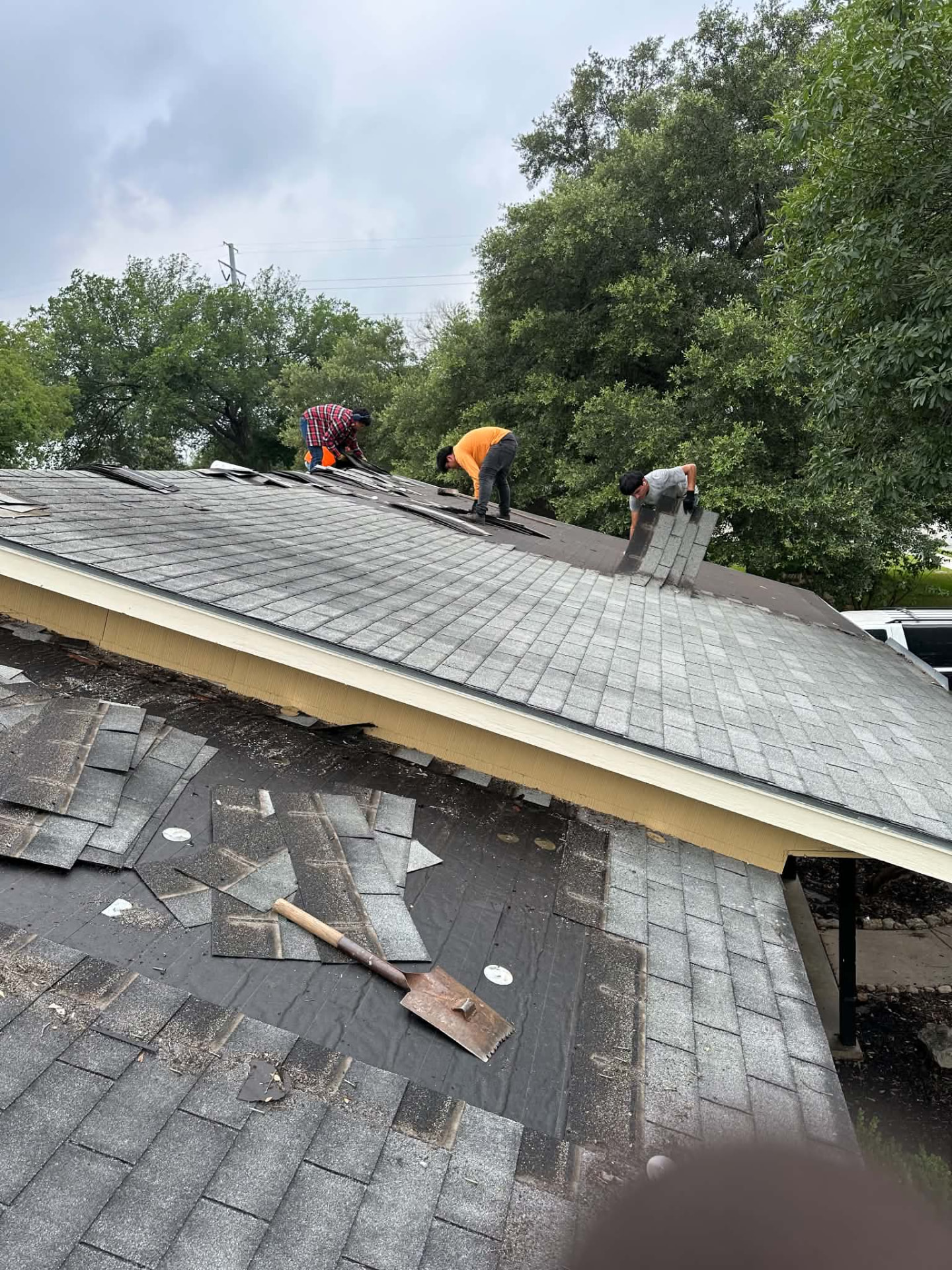 Franco crew removing existing gray shingles from a San Antonio roof