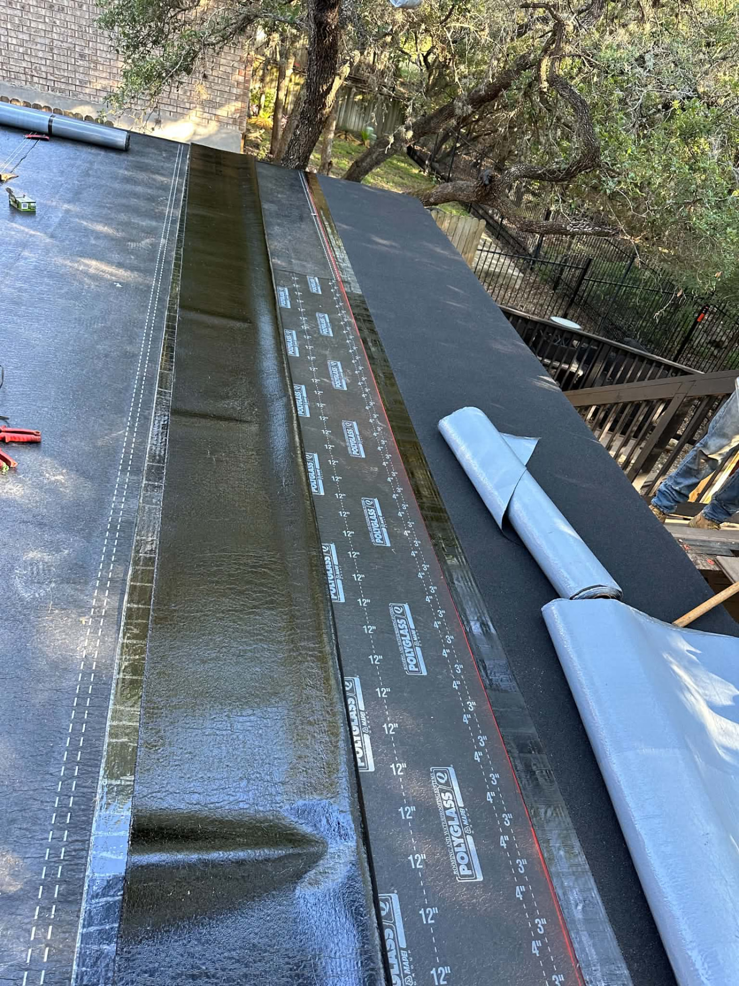 Rolled roofing sheets being installed on a low-slope surface