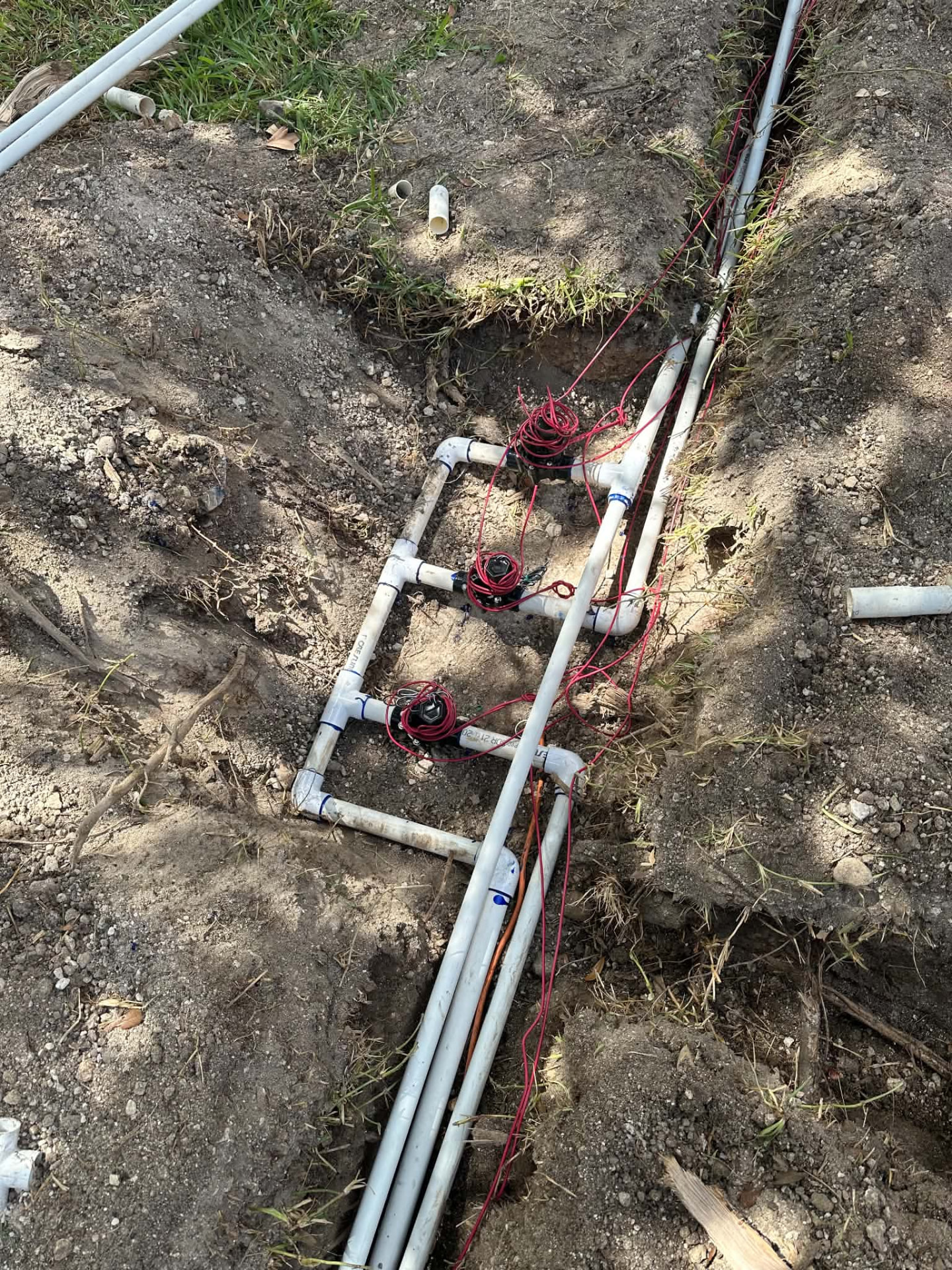 Irrigation pipes and valves being installed in an open trench